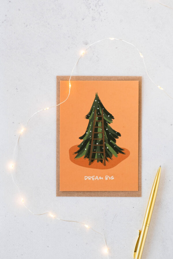 kerstkaart uit gerecycleerd papier, oranje achtergrond met kerstboom en opschrift dream big